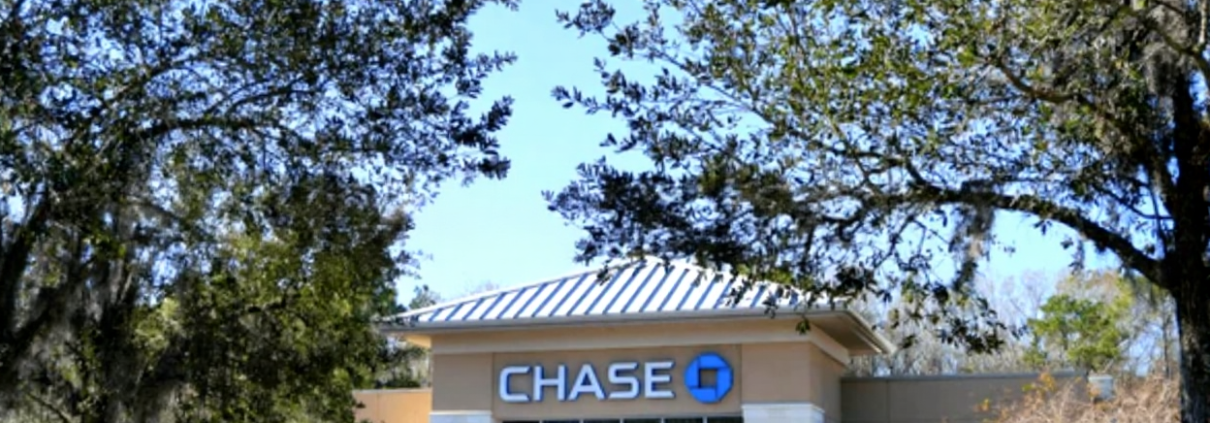 Licensed electrician installing surge protection devices in commercial electrical panel for bank lightning protection system