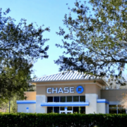 Licensed electrician installing surge protection devices in commercial electrical panel for bank lightning protection system