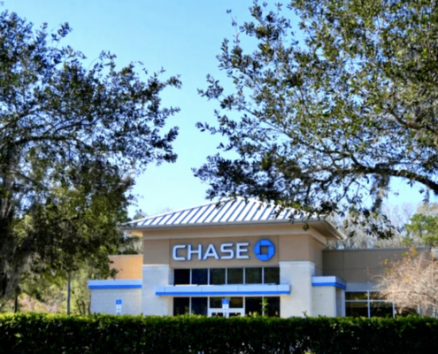 Licensed electrician installing surge protection devices in commercial electrical panel for bank lightning protection system