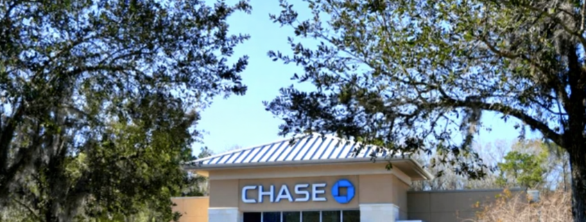 Licensed electrician installing surge protection devices in commercial electrical panel for bank lightning protection system